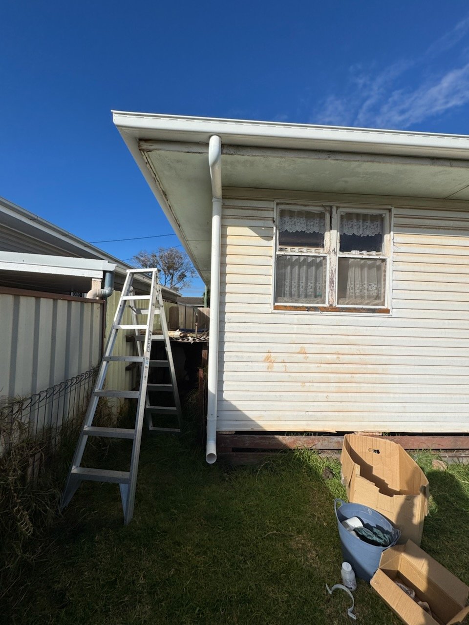 New white gutter and downpipe fitted mid-job